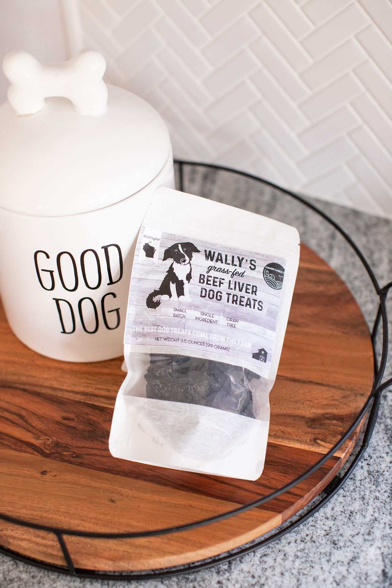 Bag of Wally’s grass-fed beef liver dog treats beside a "Good Dog" jar on wooden tray