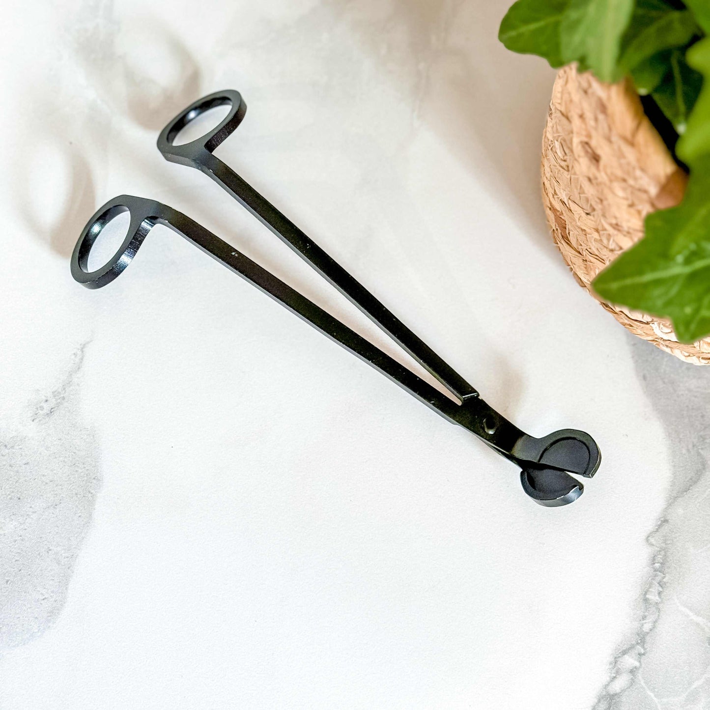 Black metal wick trimmer with built-in debris tray for candle maintenance